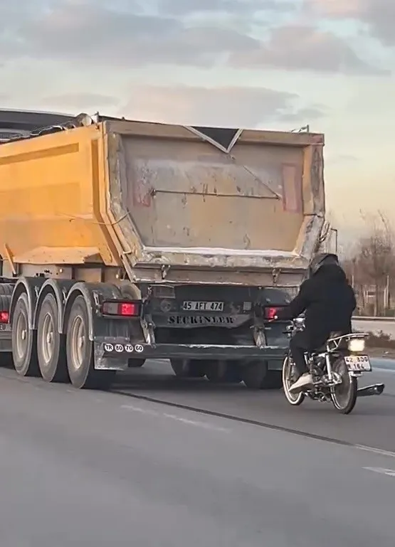 Seyir halindeki tırın peşinde motosikletli tehlikeli yolculuk
